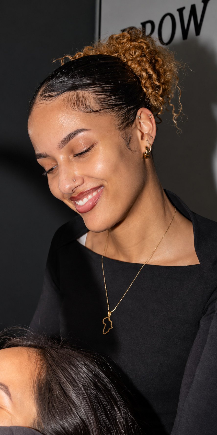Annah lacht terwijl ze een klant behandelt in The Brow Room